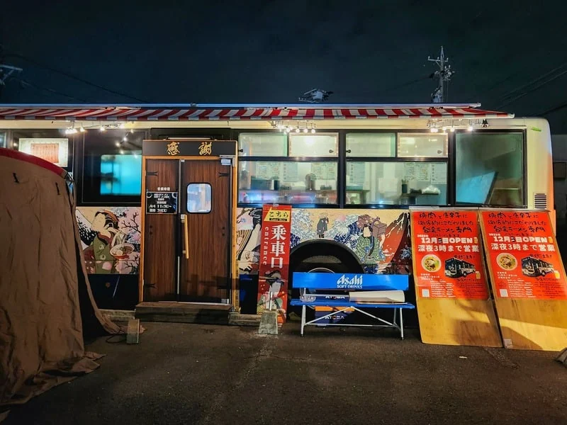 夜に営業するバス型店舗の外観